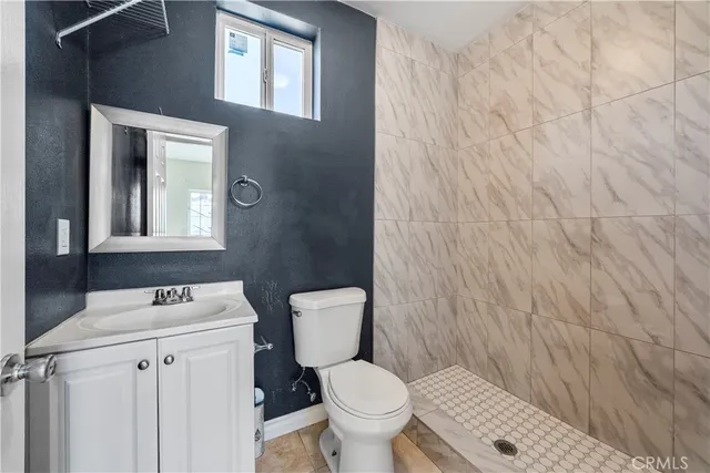 a bathroom with a toilet a sink and mirror