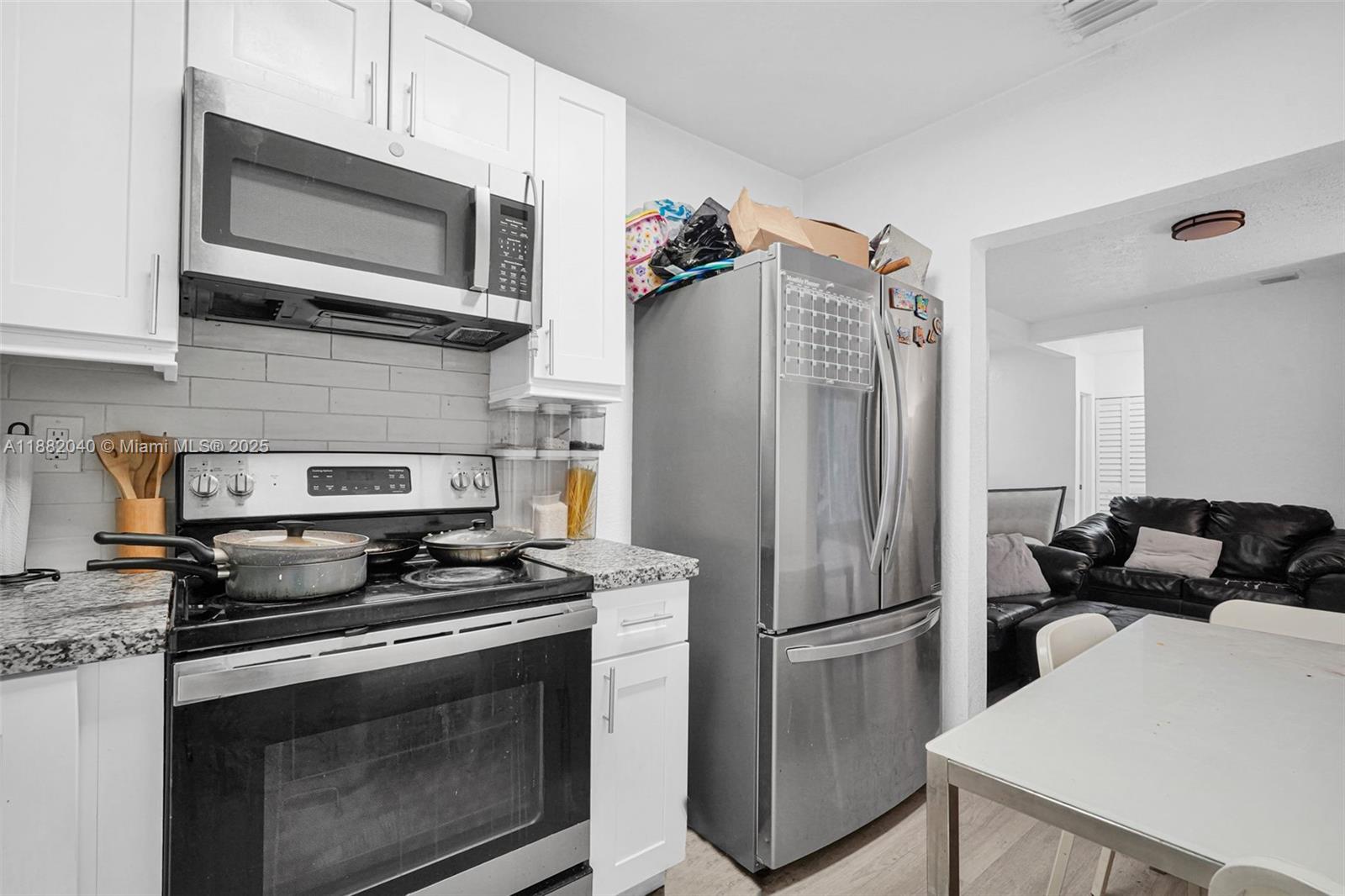1090 Northwest 77th Street Miami, FL 33150 - Photo 38 of 77 a kitchen with a refrigerator stove and microwave