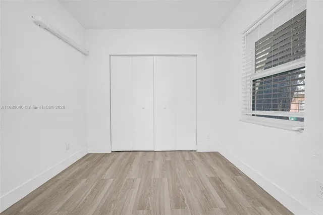an empty room with windows and closet