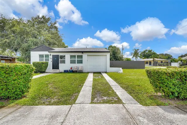 a view of a backyard with table and chairs and wooden fence