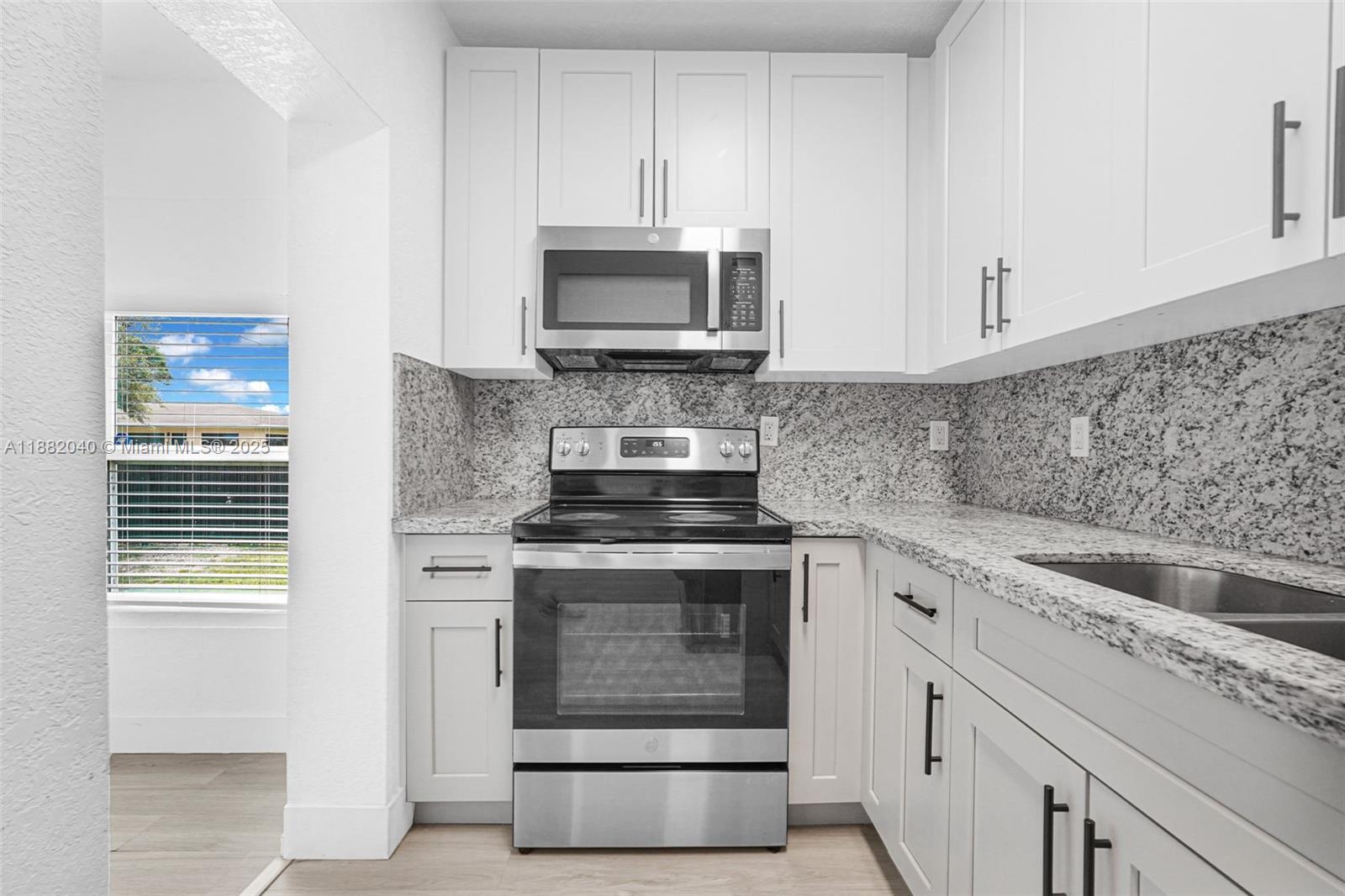1090 Northwest 77th Street Miami, FL 33150 - Photo 77 of 77 a kitchen with stainless steel appliances granite countertop a stove and a microwave