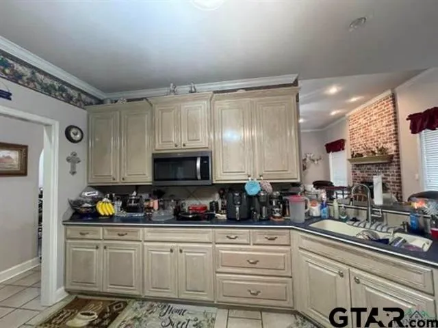 a kitchen with stainless steel appliances a sink a stove a microwave and cabinets