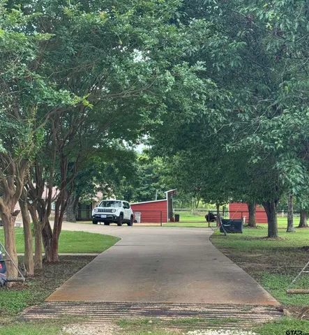 a green field with lots of trees in the background