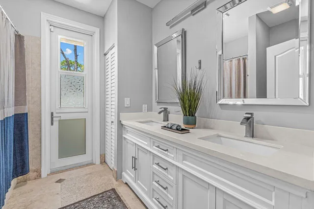 a view of a white house with a swimming pool and wooden fence