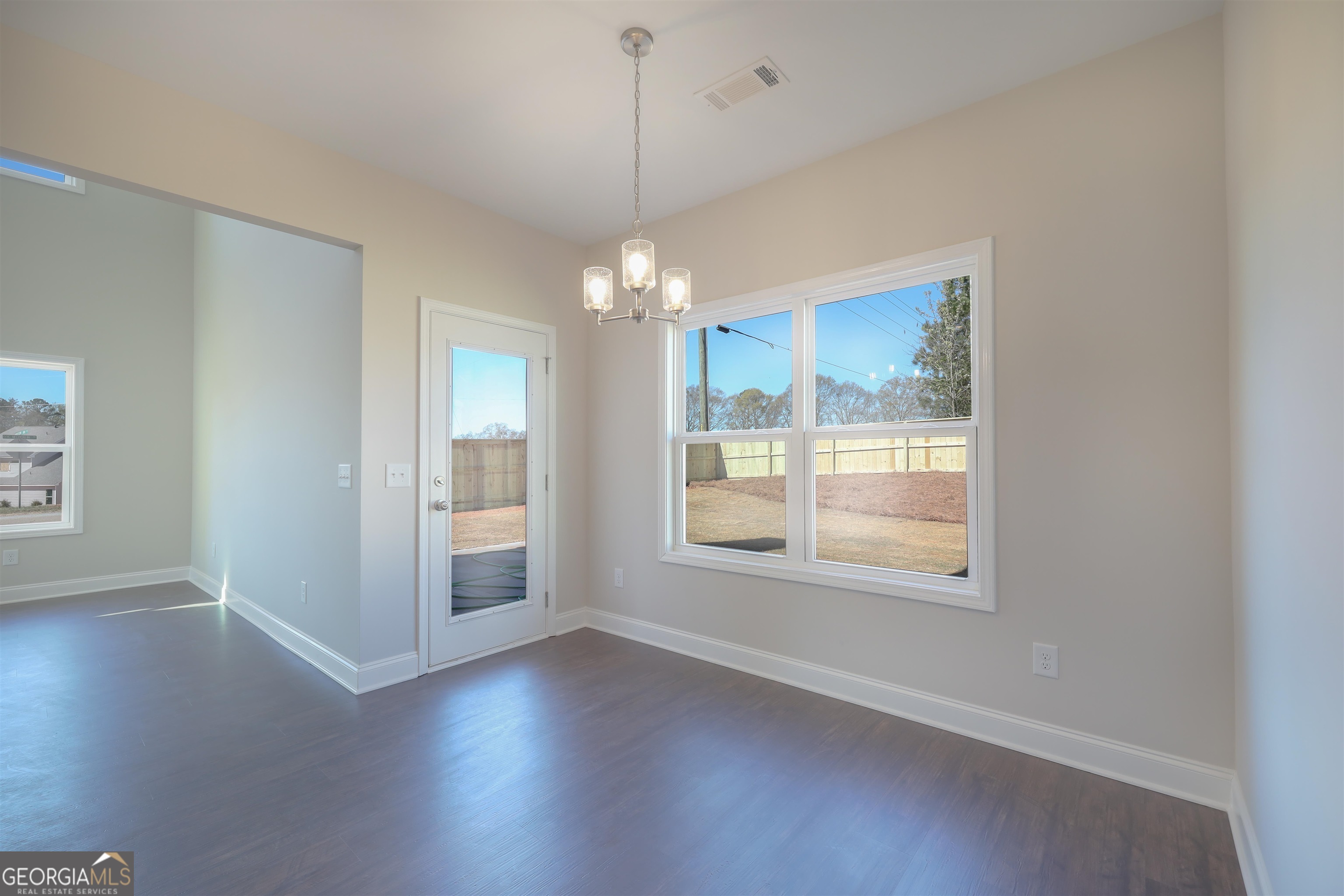 63 Delightful Way, Unit 1 Winder, GA 30680 - Photo 11 of 26 an empty room with wooden floor and windows