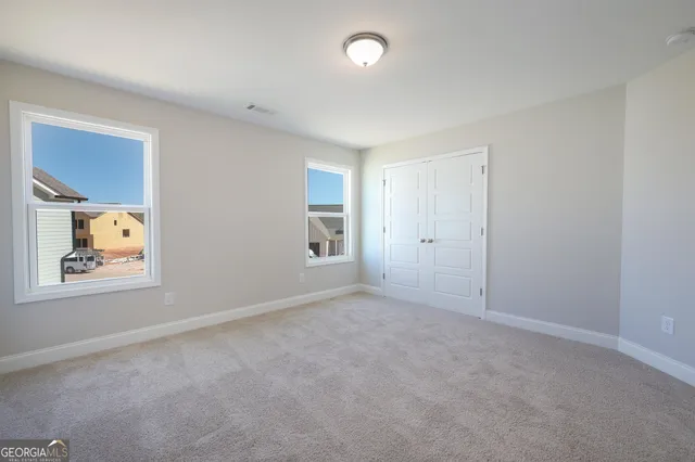 an empty room with windows and closet