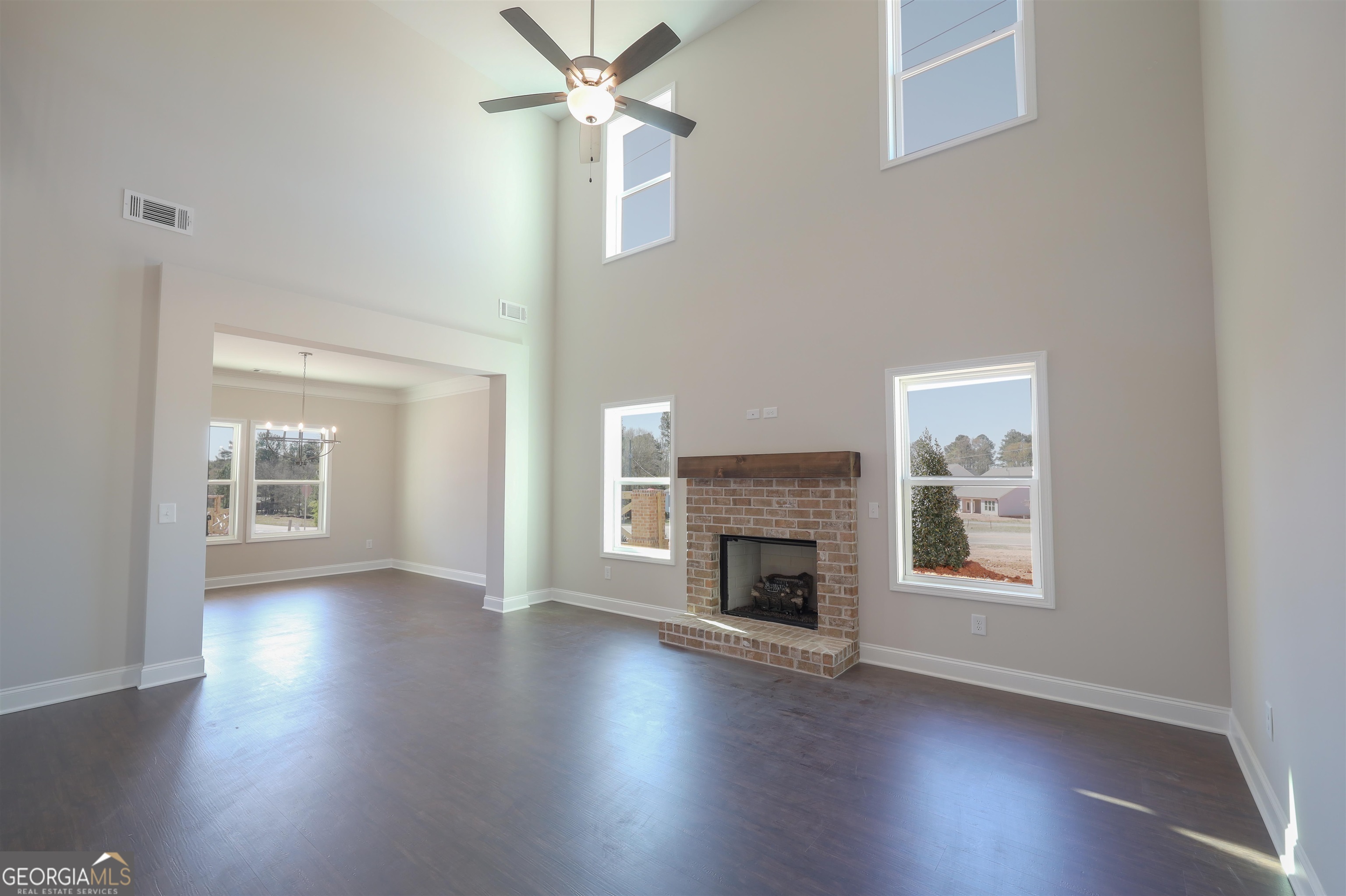 63 Delightful Way, Unit 1 Winder, GA 30680 - Photo 5 of 26 an empty room with wooden floor a fireplace and windows
