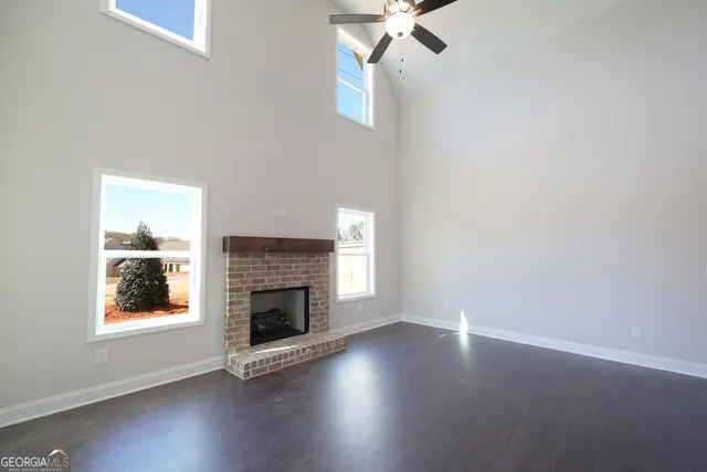 an empty room with windows and fireplace