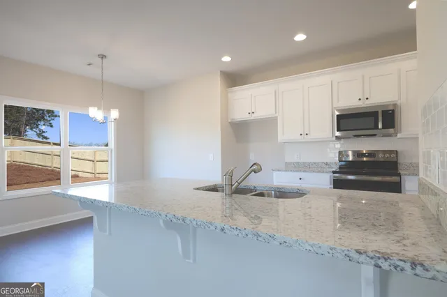 a kitchen with stainless steel appliances granite countertop a sink a stove and a refrigerator