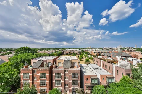 a view of a white house next to a yard with a fountain