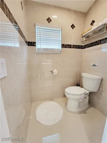a white toilet sitting next to a bathroom sink
