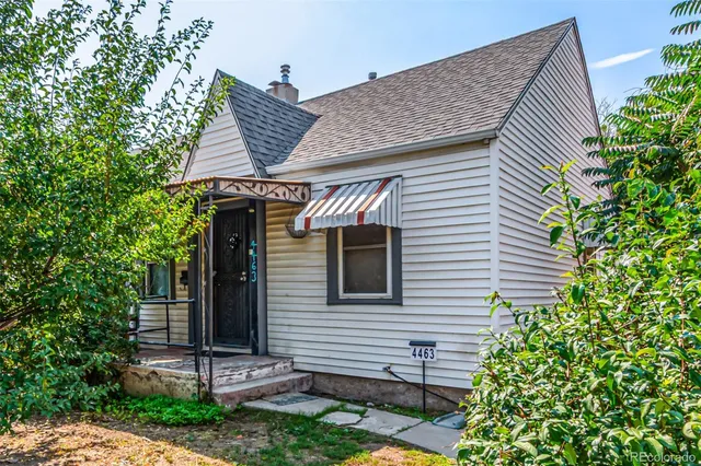 a view of house with backyard and glass windows