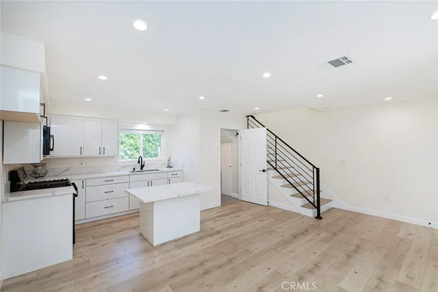 a kitchen with a sink cabinets and wooden floor
