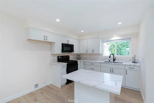a kitchen with a sink a stove and cabinets