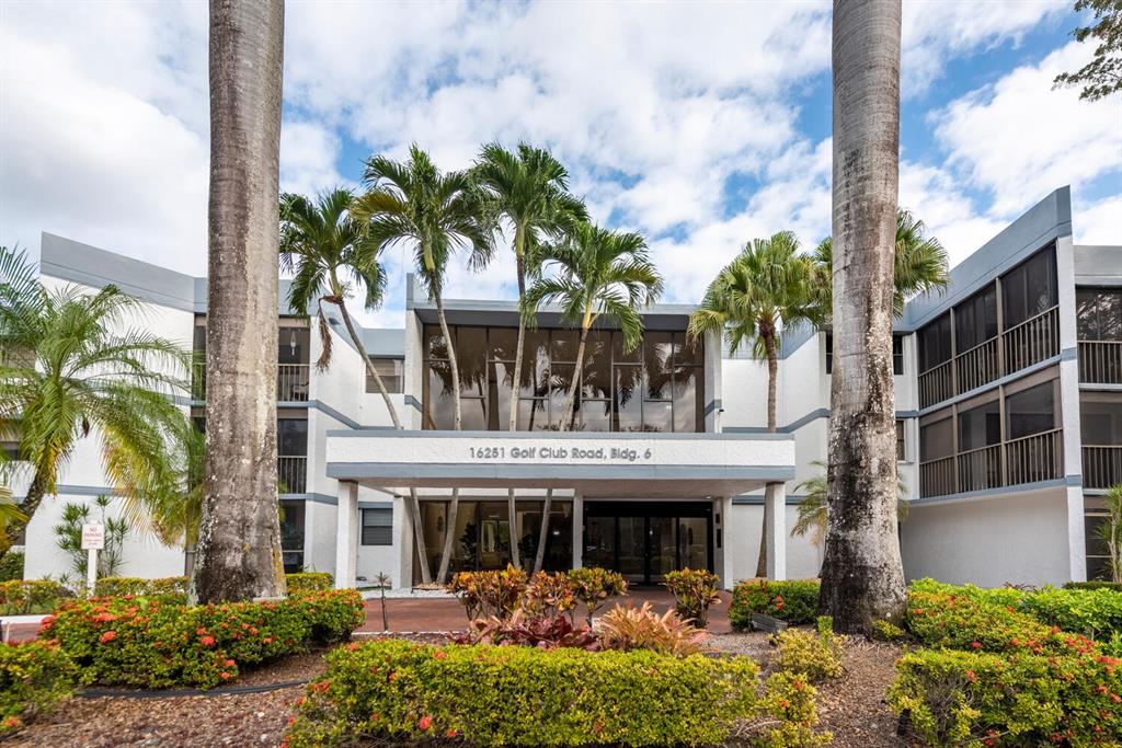 a front view of a building with palm trees