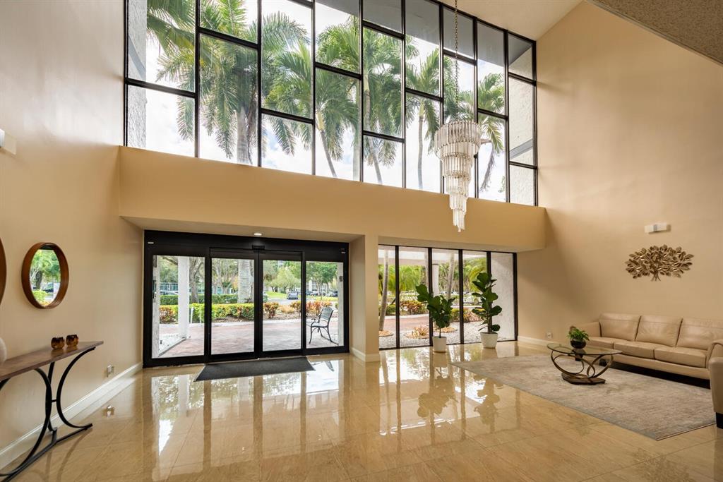 16251 Golf Club Road, Unit 305 Weston, FL 33326 - Photo 2 of 43 a view of a livingroom with furniture water view and a floor to ceiling window