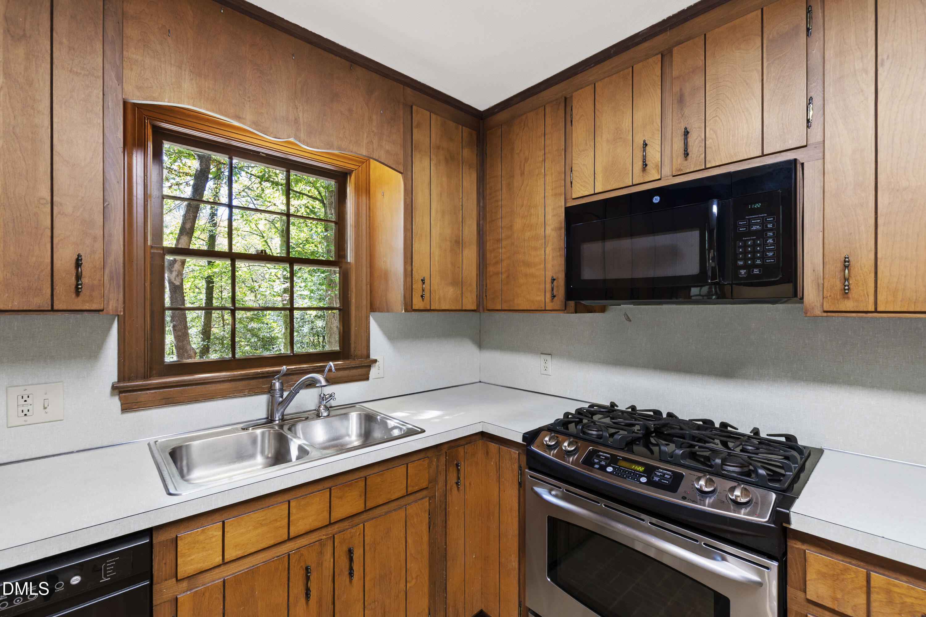 4208 Oak Park Road Raleigh, NC 27612 - Photo 17 of 66 a kitchen with stainless steel appliances a sink a stove cabinets and a window