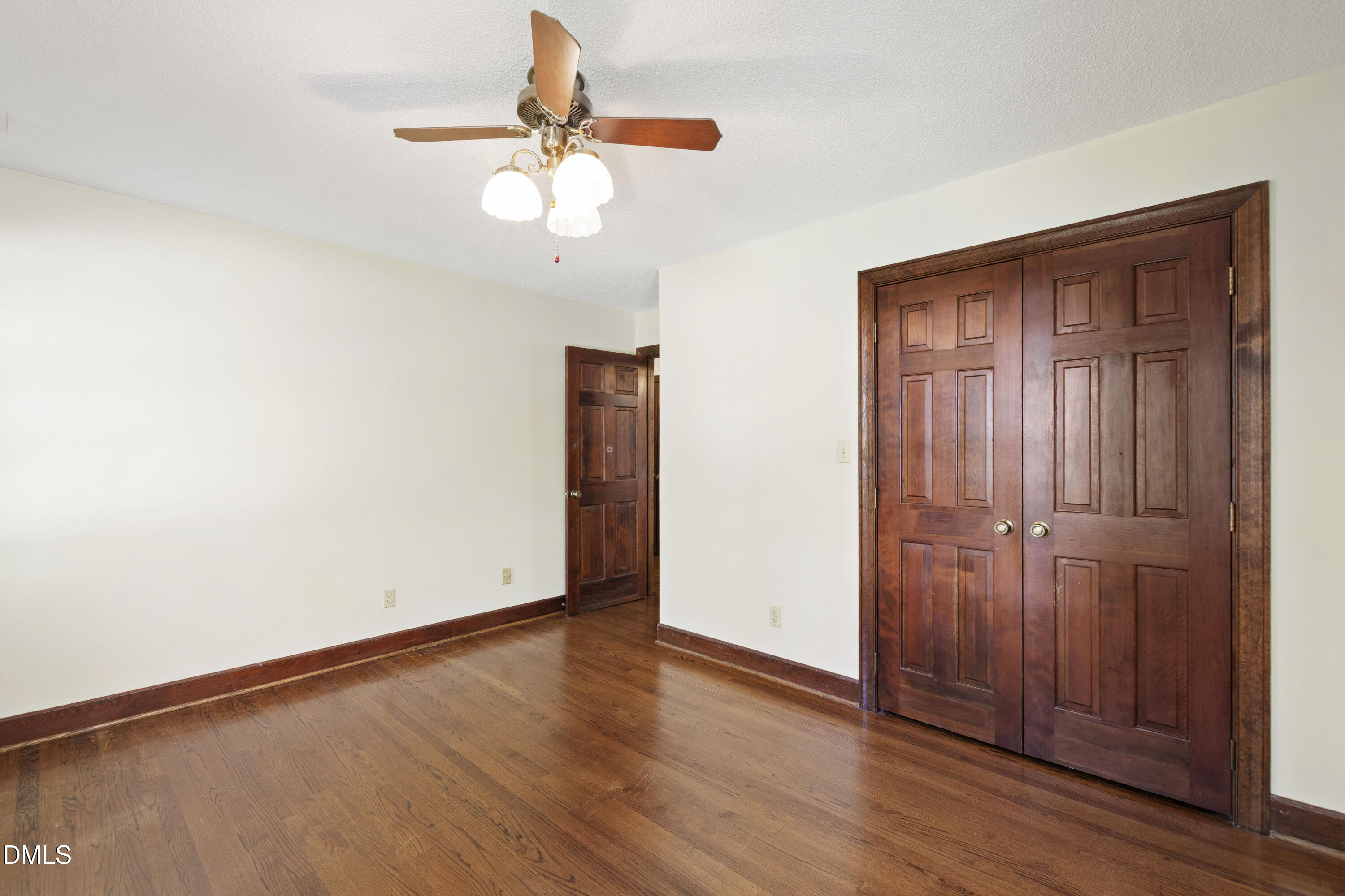 4208 Oak Park Road Raleigh, NC 27612 - Photo 45 of 66 an empty room with wooden floor chandelier fan and closet area
