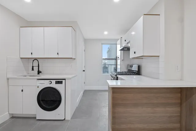 a kitchen with stainless steel appliances granite countertop a sink a stove and a refrigerator