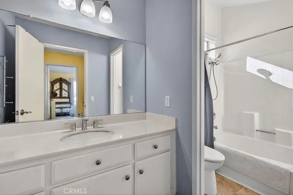 a bathroom with a sink a toilet and a large mirror