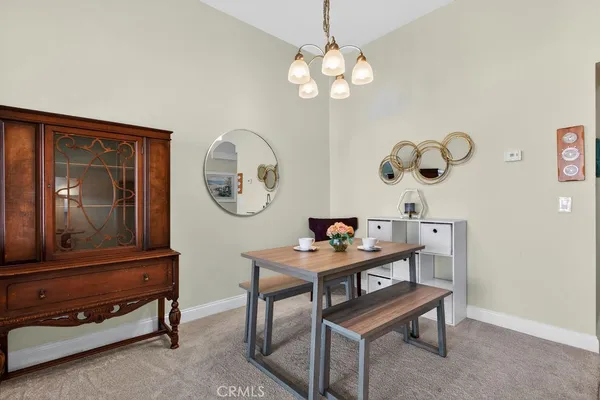 a view of a room with a table and a chandelier fan