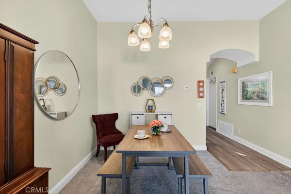 a view of a dining room with furniture a chandelier and wooden floor