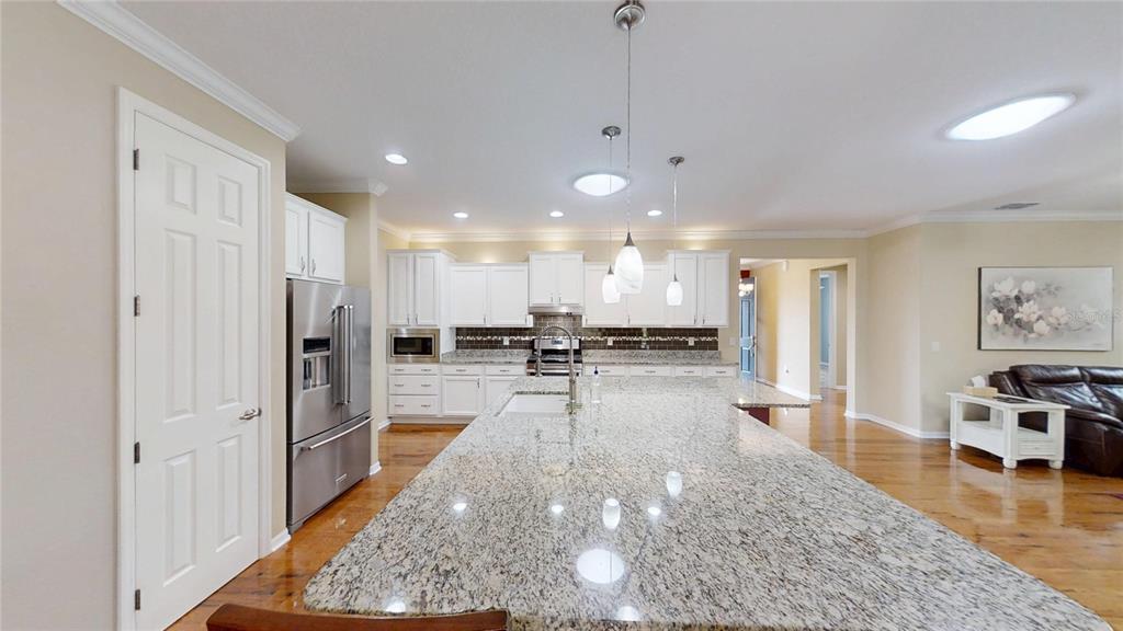 9273 Southwest 91st Ct Road Ocala, FL 34481 - Photo 14 of 38 a view of a kitchen with kitchen island a large counter top space a sink stainless steel appliances and cabinets