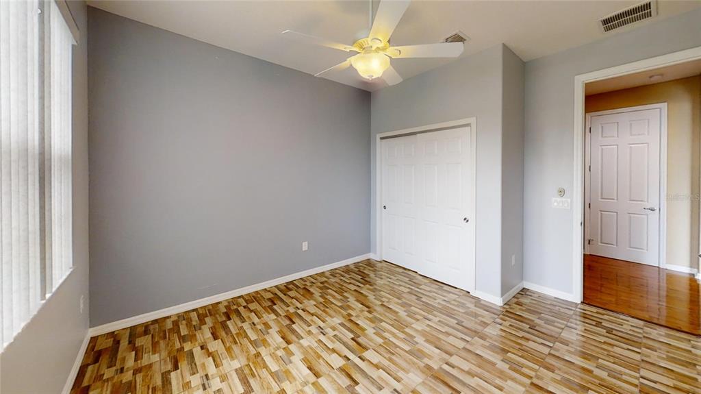 9273 Southwest 91st Ct Road Ocala, FL 34481 - Photo 29 of 38 a view of a room with wooden floor and a ceiling fan