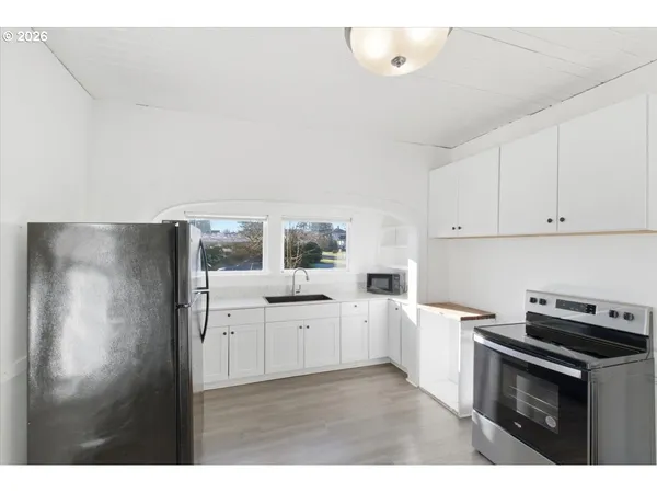 a kitchen with white cabinets and white appliances