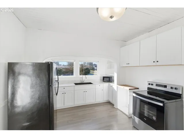 a kitchen with white cabinets and white appliances