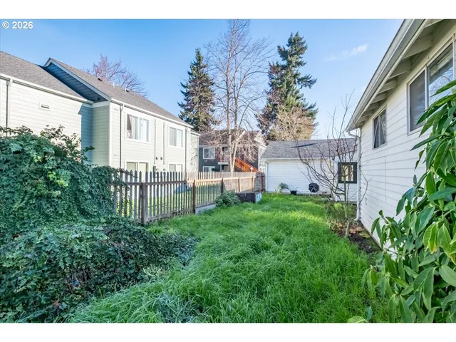 a view of backyard with potted plants and wooden fence
