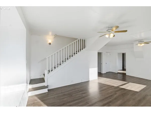 a view of an empty room with wooden floor
