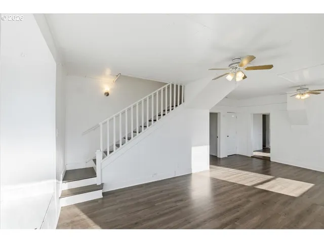 a view of an empty room with wooden floor