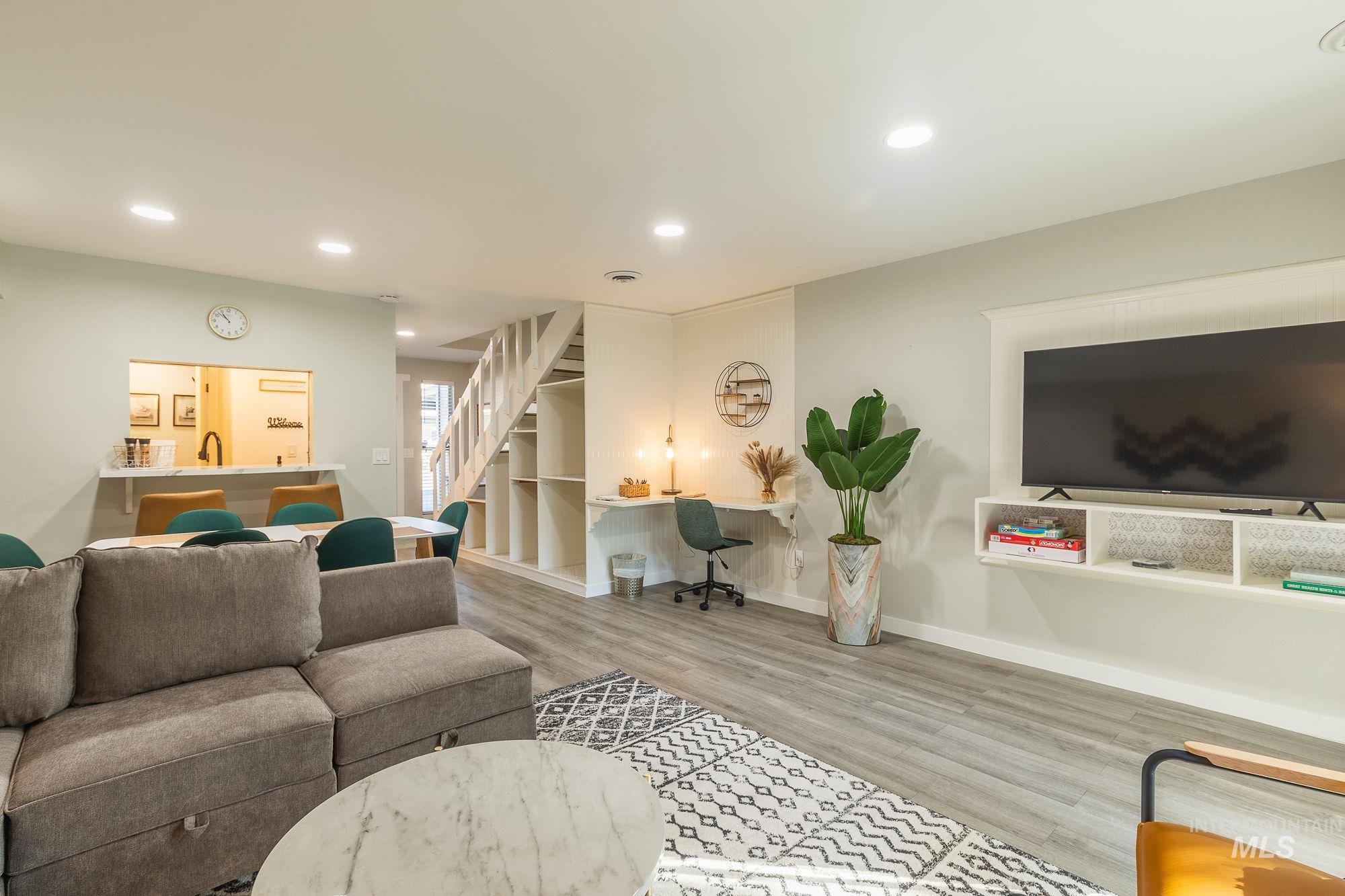 Living room featuring stairs, wood finished floors, and recessed lighting