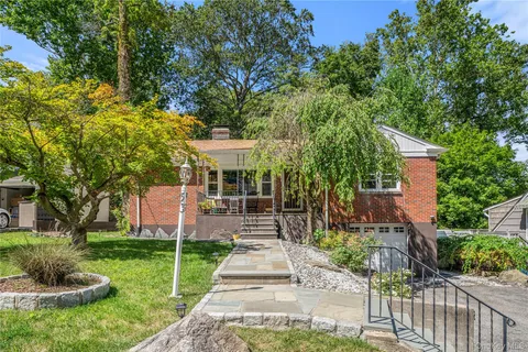 a front view of a house with a yard and fountain