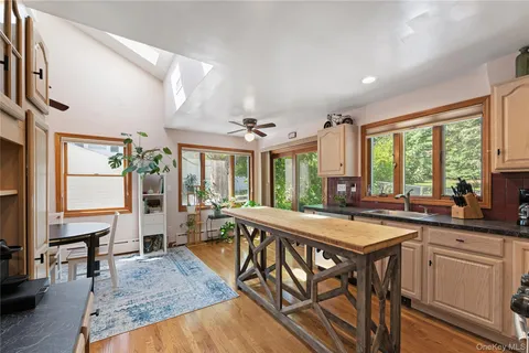a dining hall with stainless steel appliances granite countertop wooden floor a stove and a refrigerator