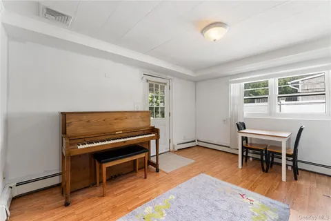 a living room with furniture a piano and wooden floor