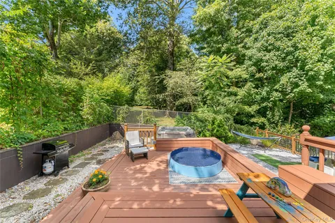 a view of a patio with table and chairs potted plants and large tree