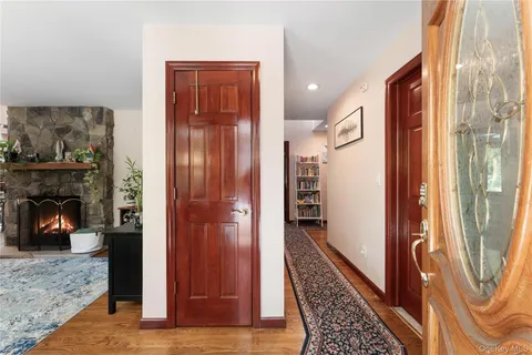 a view of a hallway with wooden floor and a fireplace