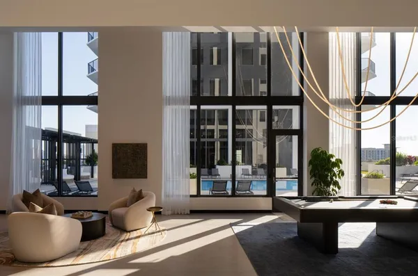 a living room with furniture and large windows