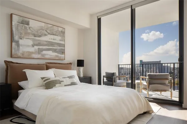 a bedroom with a large bed and a balcony view