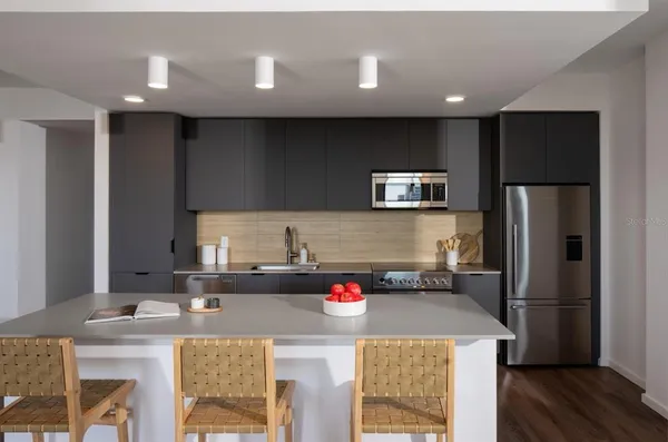 a kitchen with stainless steel appliances granite countertop a refrigerator and a stove