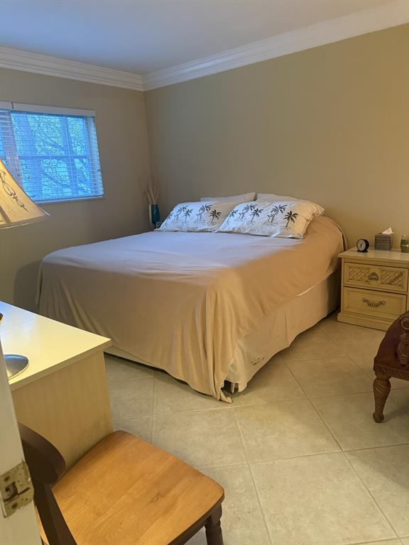 2050 Northeast 39th Street, Unit 211W Lighthouse Point, FL 33064 - Photo 15 of 30 a bed sitting in a bedroom next to a window