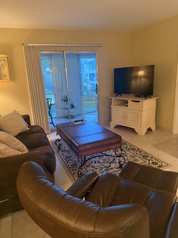 2050 Northeast 39th Street, Unit 211W Lighthouse Point, FL 33064 - Photo 8 of 30 a living room with a flat screen tv and a couch
