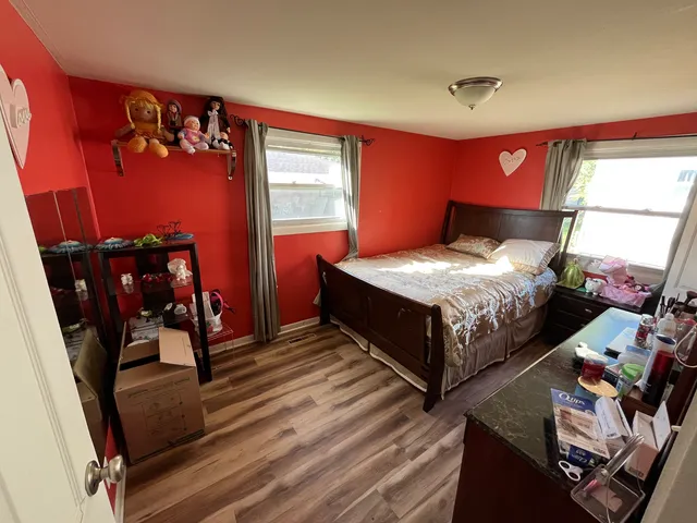 a bedroom with bed and wooden floor
