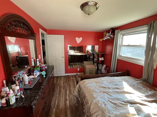 a bedroom with a bed and a large mirror on the dresser