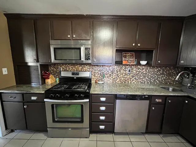 a kitchen with a sink stove and microwave