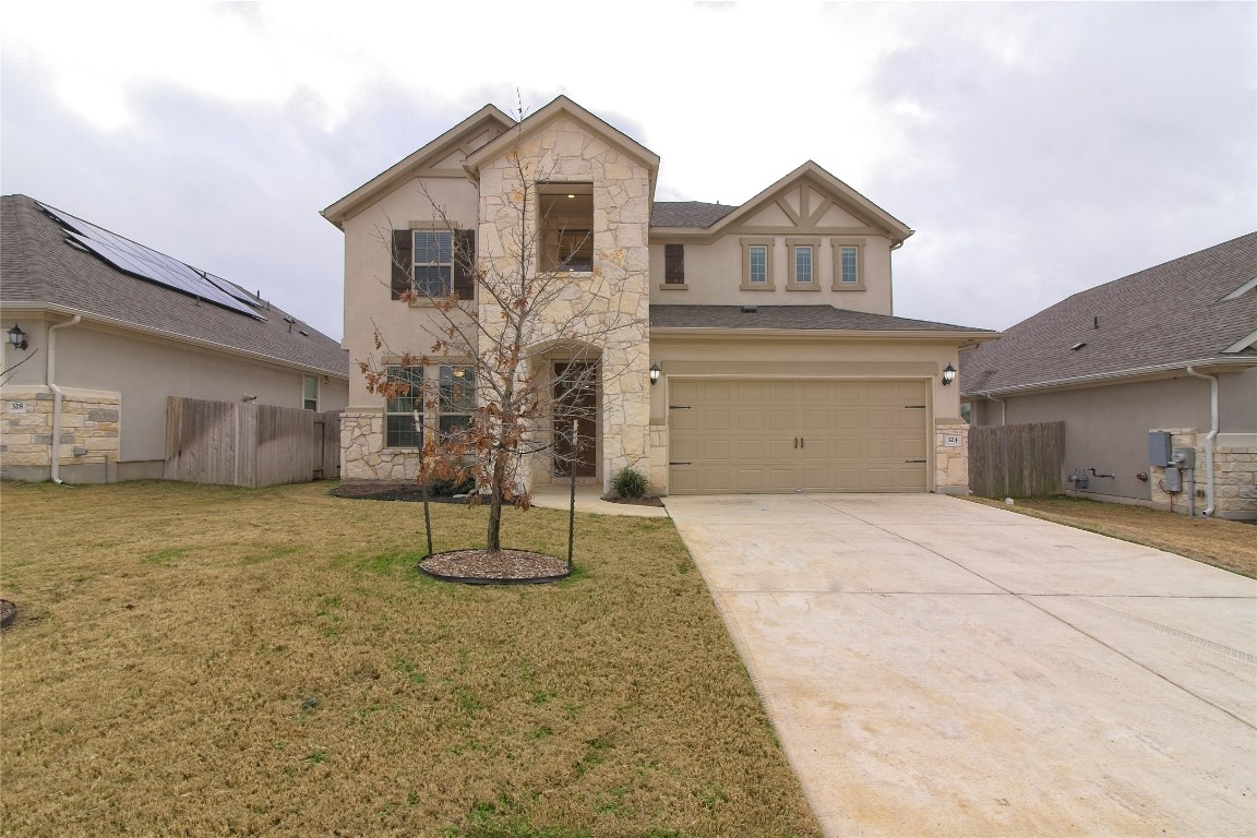 View of front of property featuring stone siding, concrete driveway, an attached garage, and stucco siding