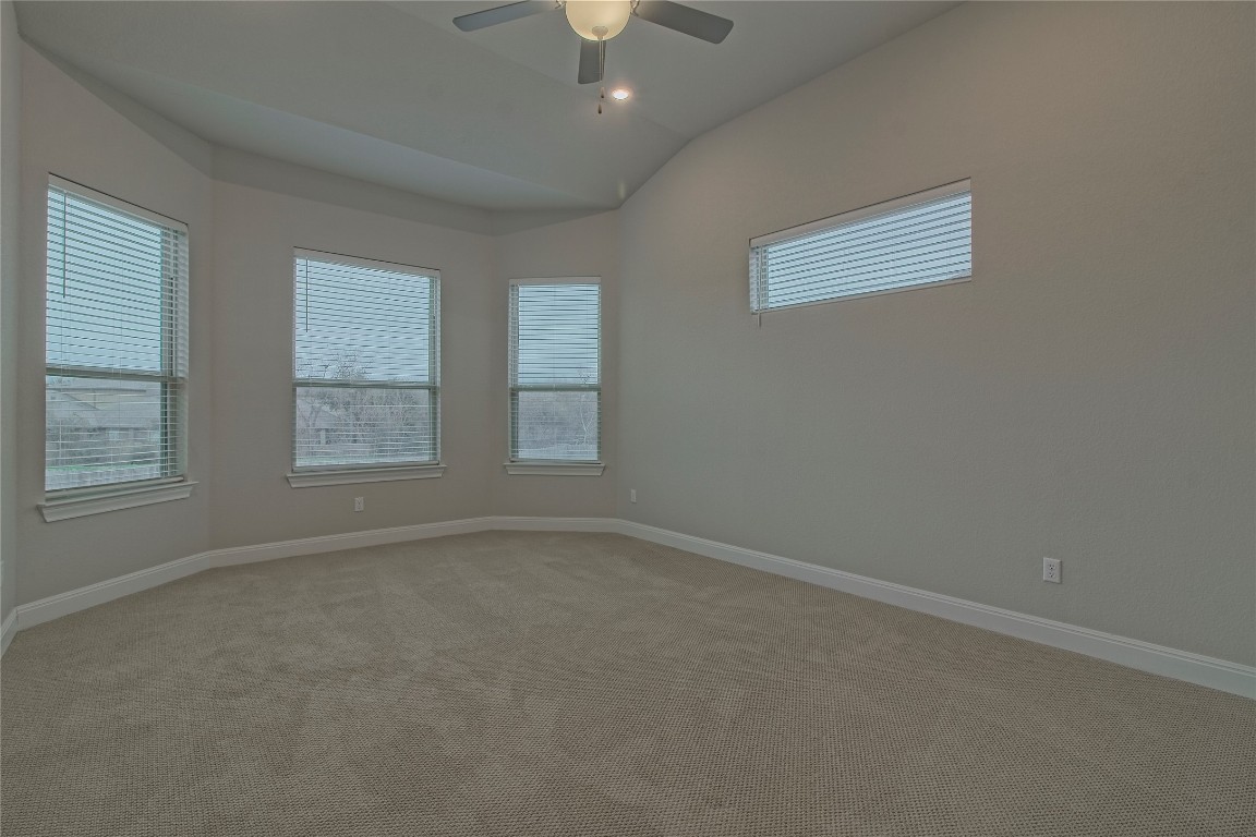 324 Windom Way Georgetown, TX 78626 - Photo 16 of 40 Carpeted spare room with vaulted ceiling and a ceiling fan