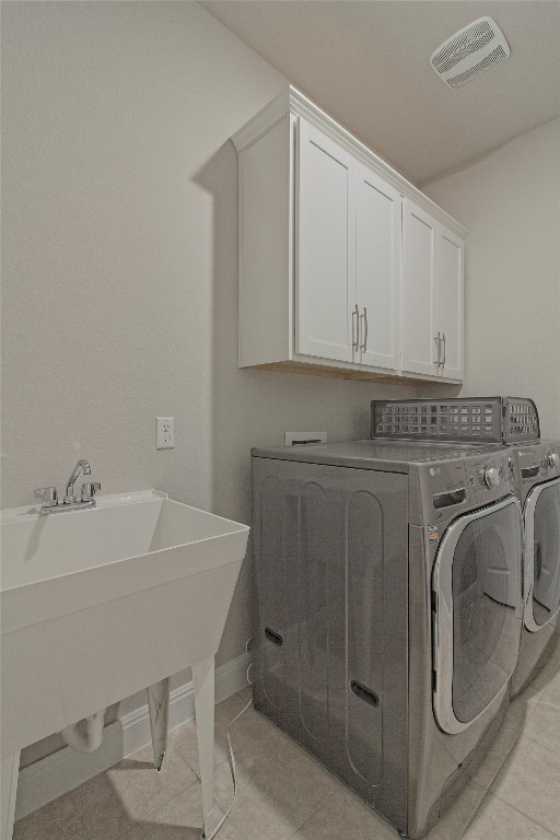 324 Windom Way Georgetown, TX 78626 - Photo 19 of 40 Laundry area with light tile patterned floors, cabinet space, and washing machine and dryer